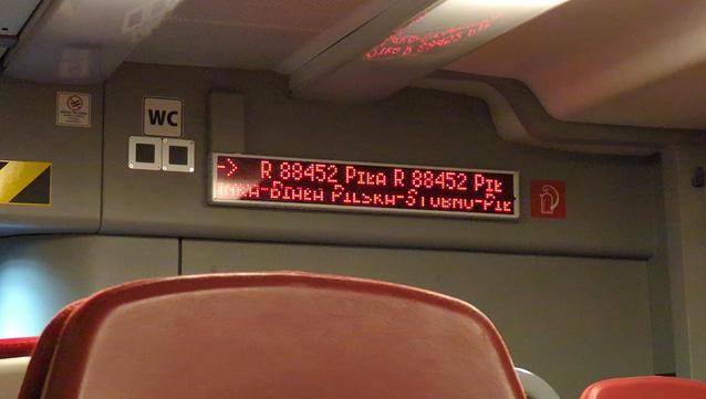 Punktowy wyświetlacz w pociągu. W pierwszym wierszu "R 88452 Piła R 88452 Pił". W drugim przewija się "nka – Biała Pilska – Stobno – Pił". Górna część liter jest odrobinę przesunięta, ze względu na opóźnienie wyświetlacza (niewidoczne gołym okiem).